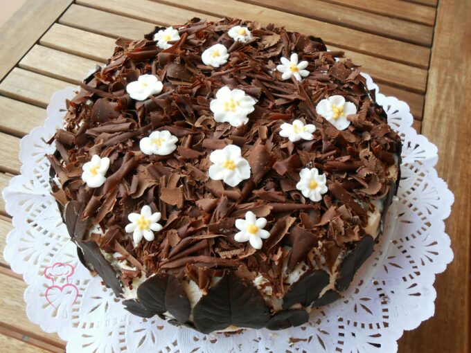 Tarta de nata con chocolate y flores de glaseado.